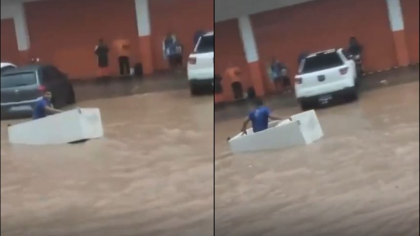 Homem usa geladeira como embarcação durante alagamento em Manaus