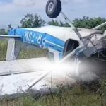 Avião danificado em acidente, capotado em meio à vegetação.