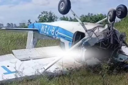 Avião danificado em acidente, capotado em meio à vegetação.