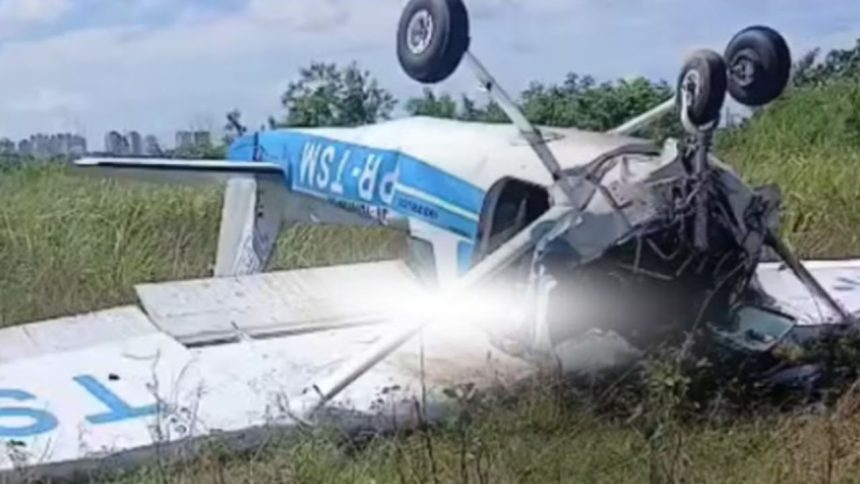 Avião danificado em acidente, capotado em meio à vegetação.