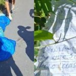 Corpo coberto por lona azul ao lado de uma folha com escrita manuscrita