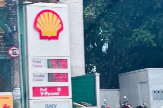 Placa de preços de combustível Shell com valores de etanol e gasolina em destaque.