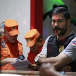 Policiais em ação em um ambiente interno, com oficiais dos Bombeiros uniformizados.