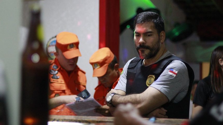 Policiais em ação em um ambiente interno, com oficiais dos Bombeiros uniformizados.