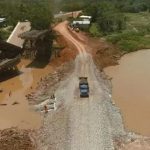 Ponte destruída sobre rio Autaz Mirim, na BR-319. Veículo trafega em estrada improvisada.