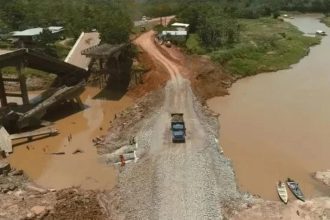 Ponte destruída sobre rio Autaz Mirim, na BR-319. Veículo trafega em estrada improvisada.