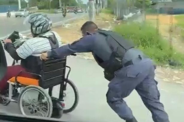 Policiais ajudam homem que usa cadeira de rodas a subir ladeira