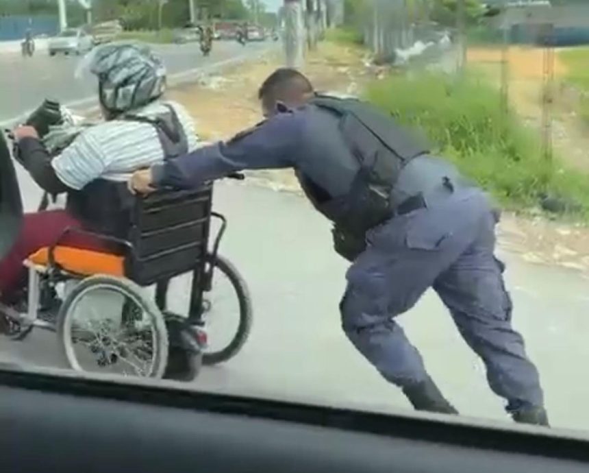 Policiais ajudam homem que usa cadeira de rodas a subir ladeira