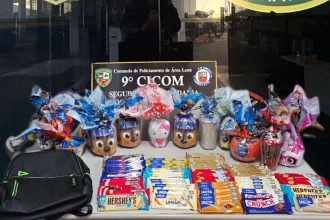 Cestas de Páscoa com ovos de chocolate decorados, barras de chocolate e mochila preta sobre a mesa.