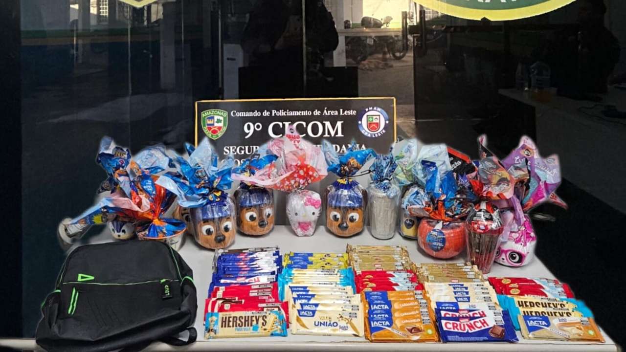 Cestas de Páscoa com ovos de chocolate decorados, barras de chocolate e mochila preta sobre a mesa.