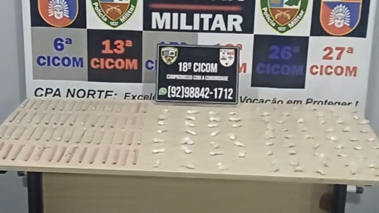 Apresentação de itens apreendidos pela polícia militar, incluindo uma placa de identificação e objetos sobre uma mesa.