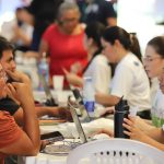 Grupo de pessoas reunidas em um evento da Defensoria Pública do Amazonas, usando laptops e interagindo.