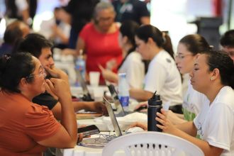 Grupo de pessoas reunidas em um evento da Defensoria Pública do Amazonas, usando laptops e interagindo.