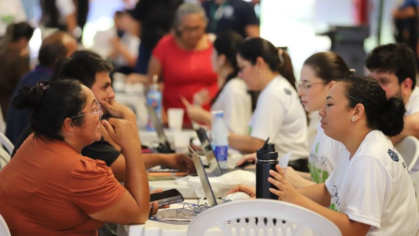 Grupo de pessoas reunidas em um evento da Defensoria Pública do Amazonas, usando laptops e interagindo.